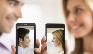 Couple holding smartphones with their pictures on